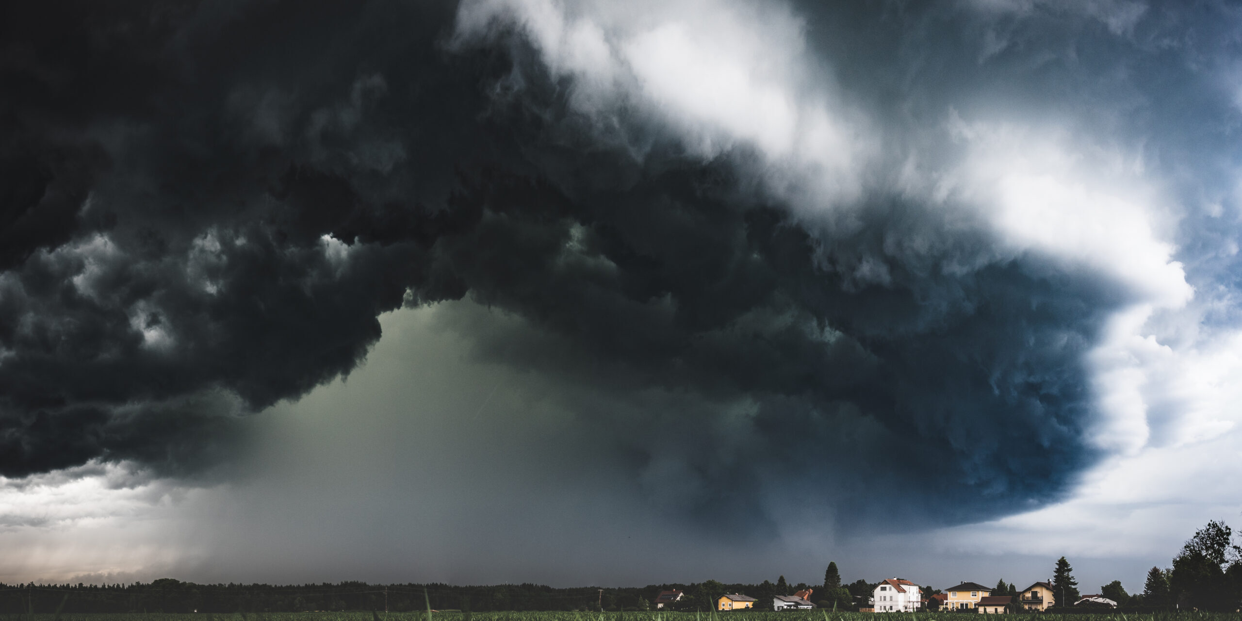Muddy wet countryside corn field and dark storm clouds. Blue tin